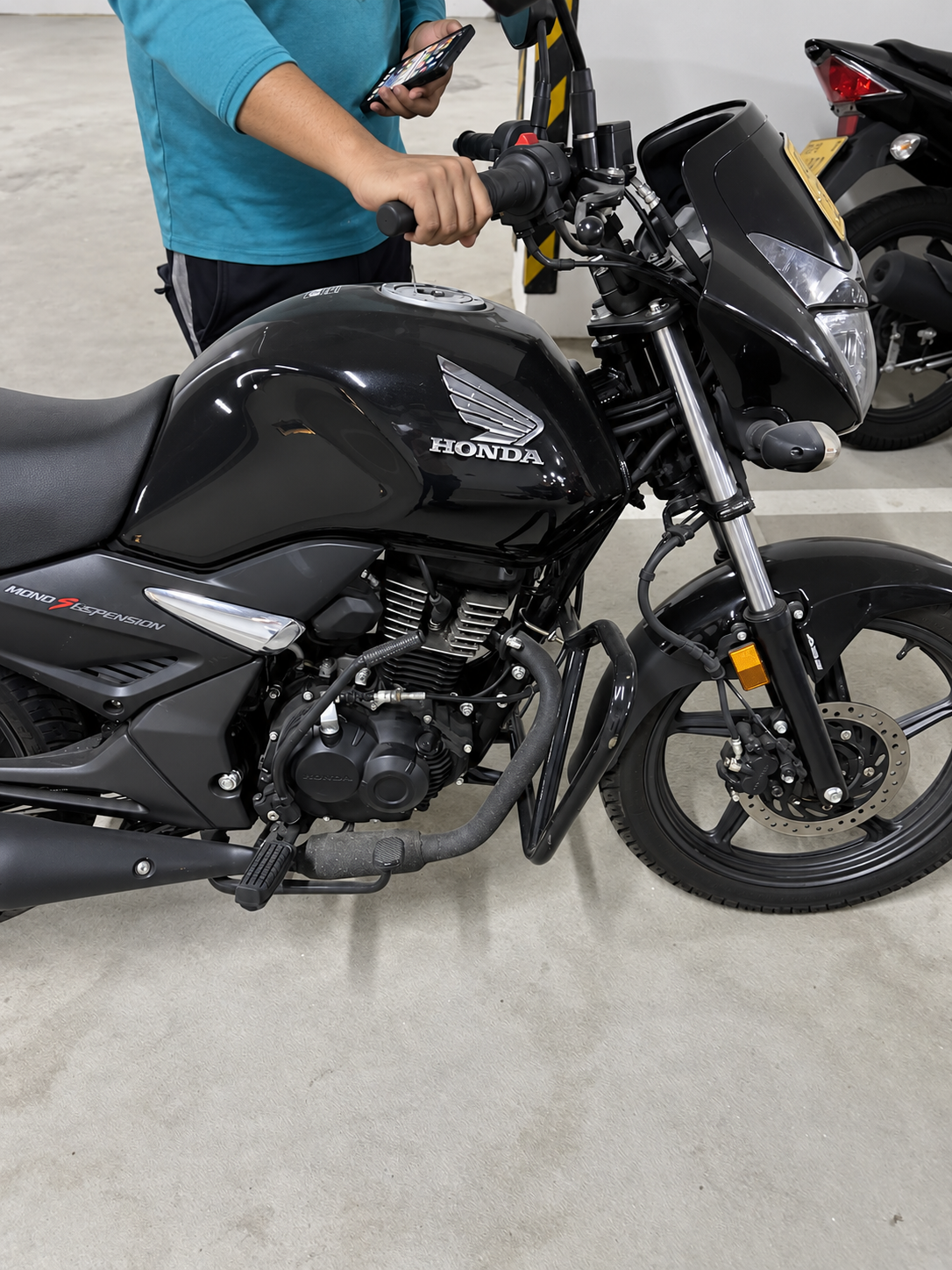 Elite Max Honda Unicorn with a hand resting on its handlebar